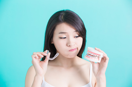 A woman trying to choose between braces or clear aligners at Raleigh Family Orthodontics in Raleigh, NC