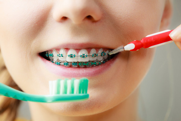 Young girl cleaning her braces