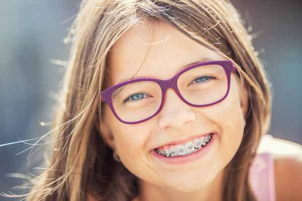 Young girl with braces smiling at Raleigh Family Orthodontics in Raleigh, NC