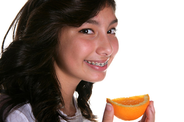 Teenage girl eating an orange slice
